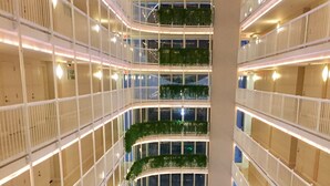 A multi-level atrium with balconies, railings, and greenery. - Sunshine Miami Vacation ☀️ (Miami)