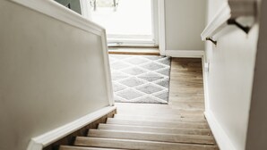 A staircase leading to a door with a view of a balcony.