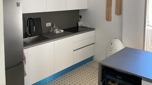 A compact kitchen with white cabinets, a black countertop, and a built-in wine cooler. - 2 bedroom private vacation home in carrara (Carrara)