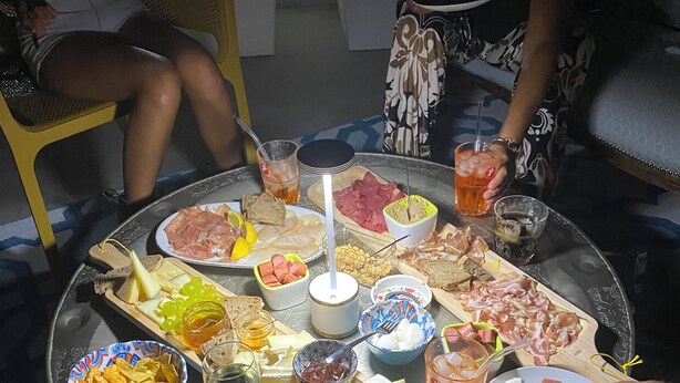 A round table with a variety of food items and drinks, including cheese, meats, and snacks. - 2 bedroom private vacation home in carrara (Carrara)