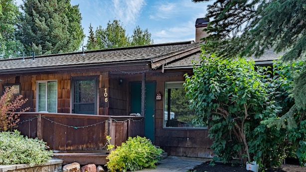 A rustic cabin with a wooden exterior, a porch, and a stone pathway leading to the entrance. - 106 Wanderers Way by Alpine Lodging Sun Valley (Ketchum)