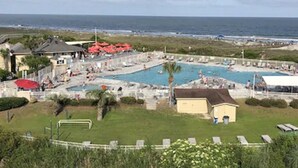 A pool area with multiple swimming pools, a beach in the background, and a few buildings. - Top Flr 3rd, Ocean View, Beach Bar & Rest, Nxt to Elevator, Pickleball & Tennis (Hilton Head Island)