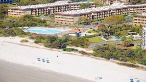 A beachfront hotel with multiple buildings, a swimming pool, and beach umbrellas. - Top Flr 3rd, Ocean View, Beach Bar & Rest, Nxt to Elevator, Pickleball & Tennis (Hilton Head Island)