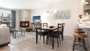 A modern living room with a fireplace, dining area, and kitchen bar. - Ski, Hike, Bike out the door. Hot Tub, Hot Pools, Gym, Pickleball,Tennis Courts (Park City)