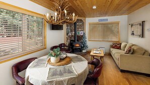 Un salon chaleureux avec une cheminée, un plafond en bois et une enseigne indiquant « St. Trails ».