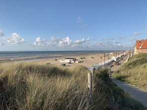 A coastal view with a beach, a boardwalk, and a building labeled 'OSCAR'. - Boutique vacation home, De Haan, sleeps 6, fully renovated in 2020, child-friendly (De Haan)