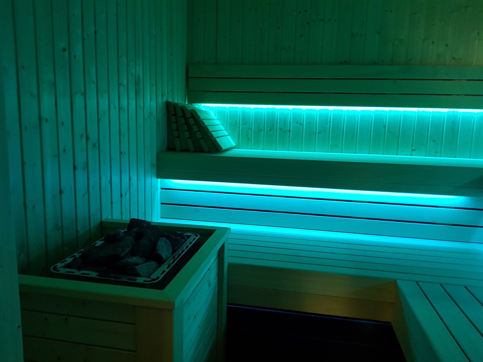 A sauna with wooden benches and a bench with a towel.