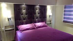 A bed with a tufted headboard, two bedside tables, and a wall-mounted lamp. - HERMOSO DEPA CENTRO HISTORICO (Guadalajara)