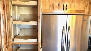 A kitchen with wooden cabinets and a stainless steel refrigerator.
