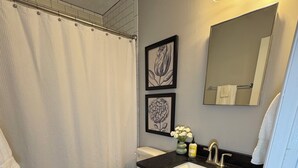 A bathroom with a toilet, sink, and shower curtain.