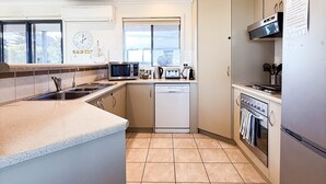 Una cocina moderna equipada con lavavajillas, microondas, estufa y horno.