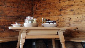 Une table en bois, sur laquelle sont posés des bols et des pots, probablement remplis de nourriture, dans une pièce rustique aux murs en bois.