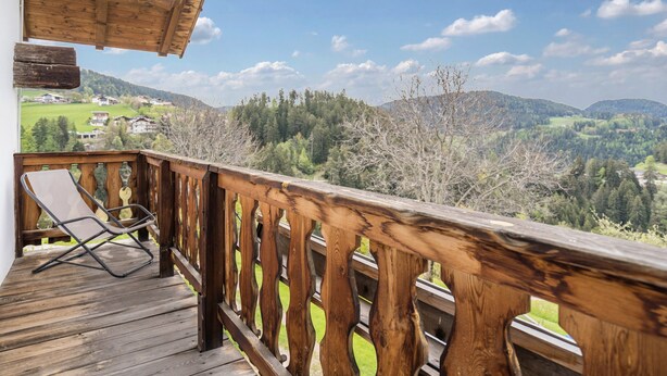 Eine Holzterrasse mit Blick auf eine Berglandschaft.