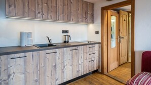 Eine moderne Küche mit Holzschränken, einer Kaffeemaschine und einem Wasserkocher.