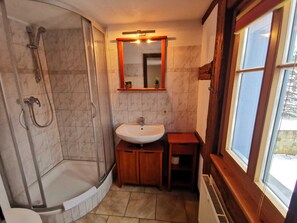 A bathroom with a shower, sink, and a small window. - Doppelzimmer - Pension Bauernhaus Vetter (Gohrisch)