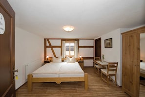 Una camera da letto con un letto di legno, un tavolino e una sedia.