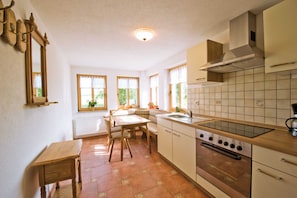 A kitchen with a wooden table, a stove, and a sink.