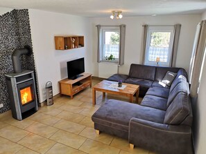 Un salon avec une cheminée, un canapé, un téléviseur et une table basse.