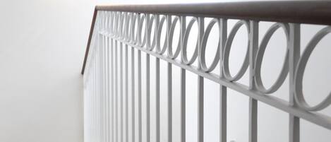 Una escalera con barandillas blancas y suelo de mármol.