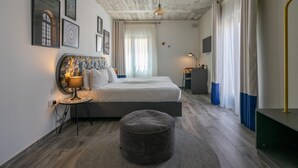 A modern bedroom with a bed, bedside table, lamp, and artwork on the wall. - Lady Todd (Sliema)