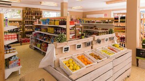 A grocery store interior with wooden crates of fruits and shelves stocked with various products. - Beachside Bungalow Escape (Cambrils)