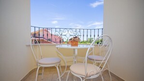 A small balcony with a white metal table and two white metal chairs. - Apartment with pool, 3 persons, garden, air-conditioned, family-friendly (Nova Vas)