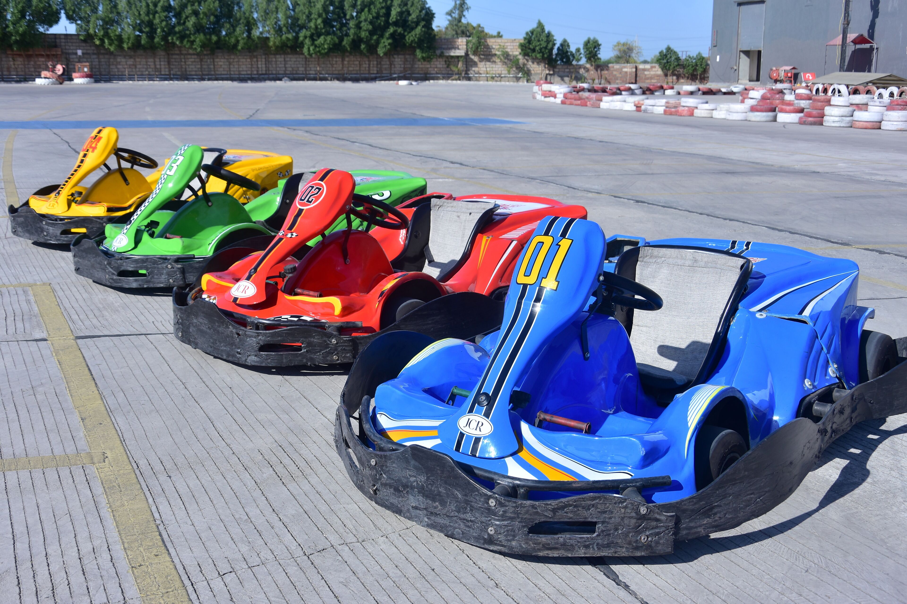 Go-karts lined up in a row on a paved surface.