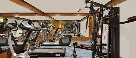 A gym with treadmills, elliptical machines, and weight machines.