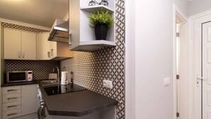 Una cocina compacta con microondas, tostadora y una pequeña isla.