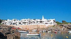 A coastal town with white buildings, rocky shoreline, and boats in the water. - Villa Casa Nova, Piscina, Wifi, AC gratis (Sant Lluís)