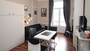 Una sala de estar moderna con un sofá, una mesa de comedor y un televisor.