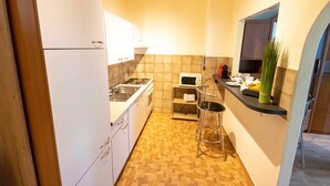 A compact kitchen with white cabinets, a microwave, a toaster, and a sink. - Studio mit Garten - Casa Lauda in Bad Vöslau (Bad Vöslau)