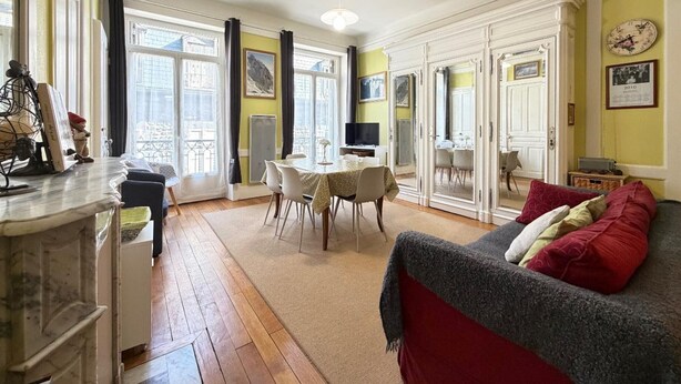 A spacious living area with a dining table, a sofa, and a television. - 2* Studio in City Center with Balcony & WiFi (Mont-Dore)