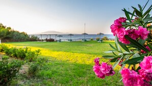 A grassy area with a view of the sea and mountains in the background. - Baywatch Apartments (Zakynthos)