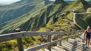 Una escalera de madera que asciende por una montaña, con vistas al paisaje circundante.
