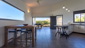 Una cocina amplia con comedor, ventanas grandes y vistas al exterior.