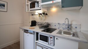 A compact kitchen with a microwave, built-in oven, and a sink.