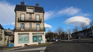 Ein Gebäude mit 'Groupama'-Beschriftung, einer Zebrastreifenmarkierung und blauem Himmel.