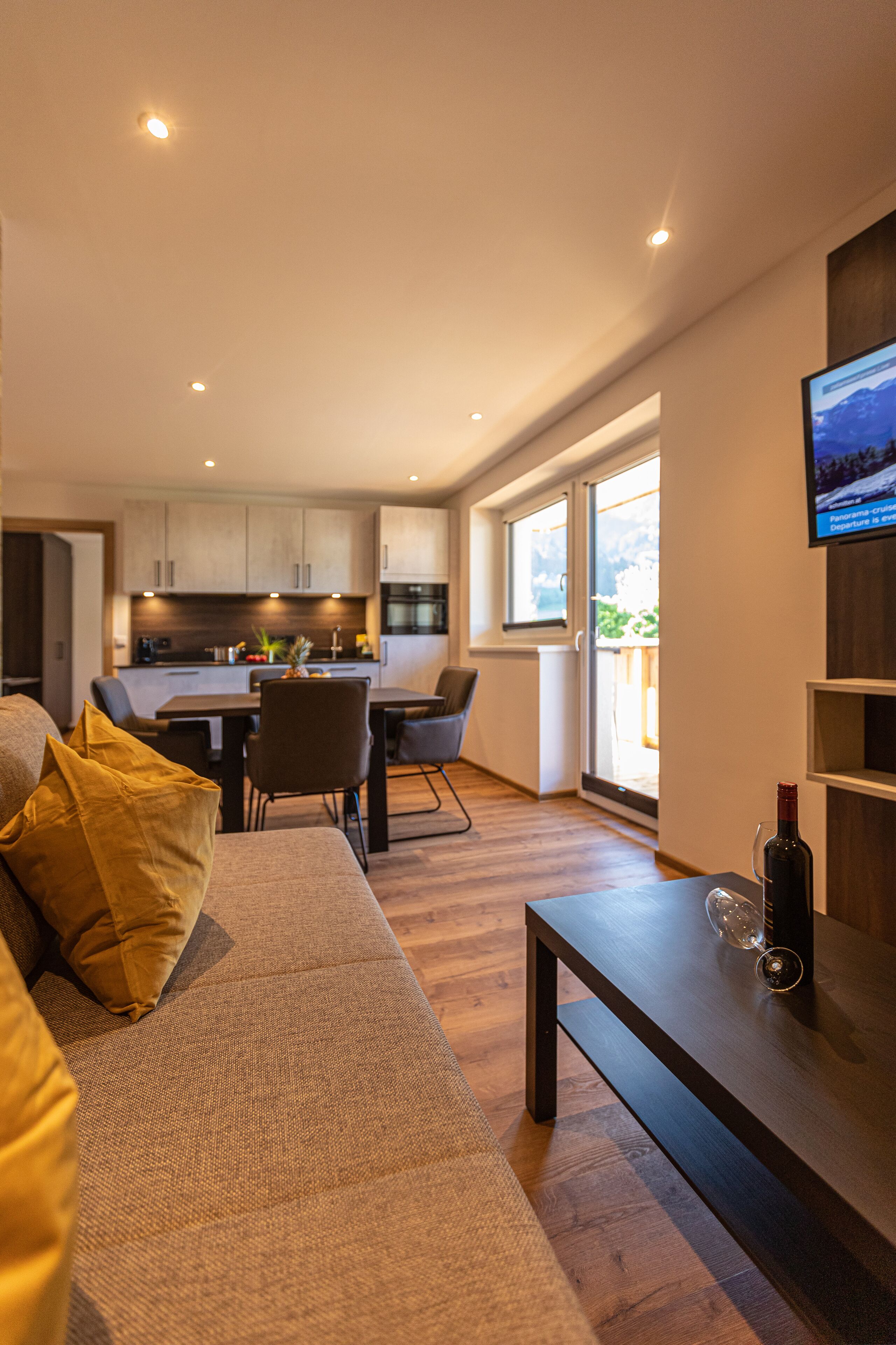 A modern living room with a sofa, a coffee table, and a TV mounted on the wall.