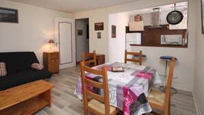 A compact living space with a dining area, kitchenette, and a sofa. - Central T2 near spa with wifi (Mont-Dore)