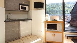 A compact kitchen with a microwave, sink, and a small oven.