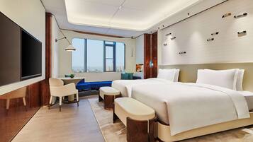 Ein modernes Hotelzimmer mit einem großen Bett, einem Schreibtisch und Blick auf die Stadt.