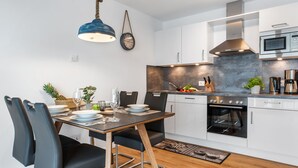 Une cuisine moderne avec des armoires blanches, un four encastré et un four à micro-ondes.