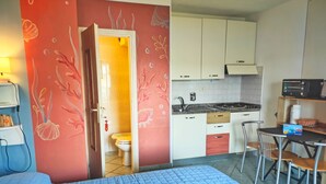 Una stanza con un letto, angolo cottura e bagno.