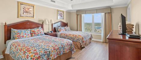 Habitación de hotel con dos camas, un escritorio, un televisor y vistas del paisaje.