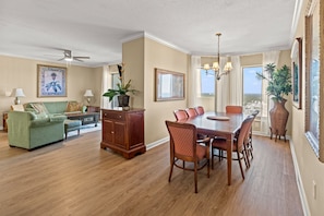 Relax in the spacious living and dining area, featuring a green sofa, wooden coffee table, and dining table with six chairs.