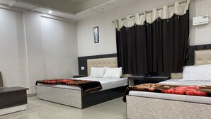 Ein Hotelzimmer mit zwei Betten, einem Nachttisch und einer Wand-Klimaanlage.