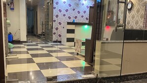 Eine Hotelhalle mit Schachbrettmuster Boden, einer Rezeption und einer Wand mit Muster.
