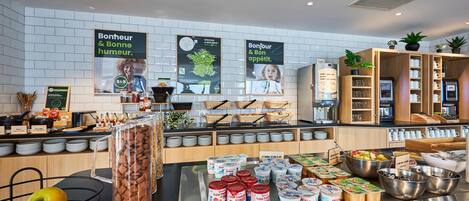 A breakfast buffet with various food items and a coffee station.
