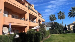 A multi-story building with balconies, a satellite dish, and a well-maintained lawn. - IDEAL FOR FAMILY HOLIDAYS (AN)